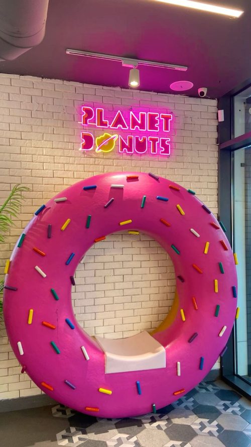 pink donut bench sculpture display in shopping mall